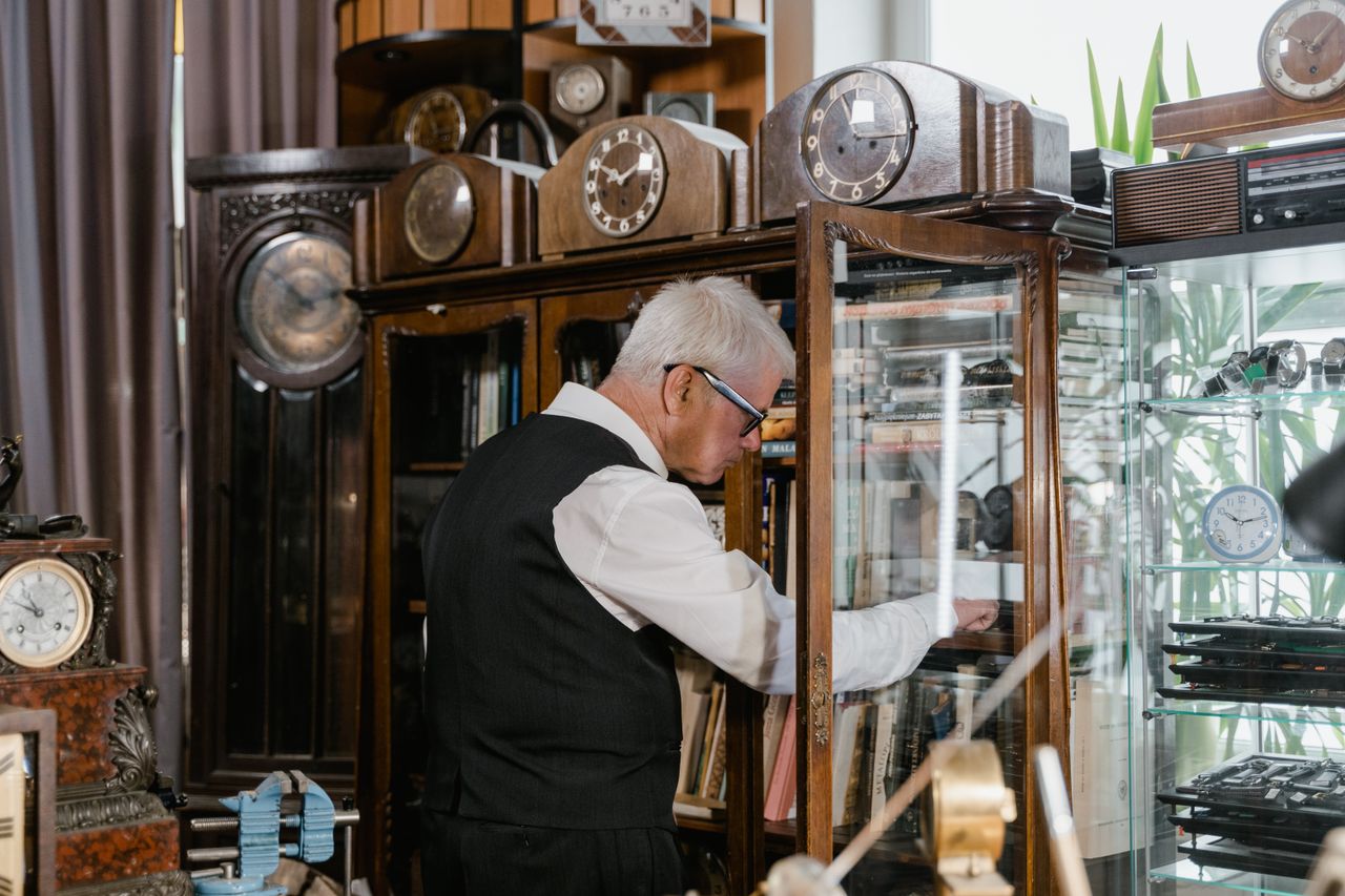 Appraiser examining antique clocks before they go to auction